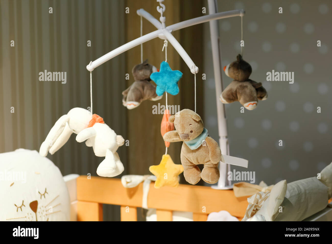 Baby crib rotating mobile with soft toys hanging in the nursery Stock Photo