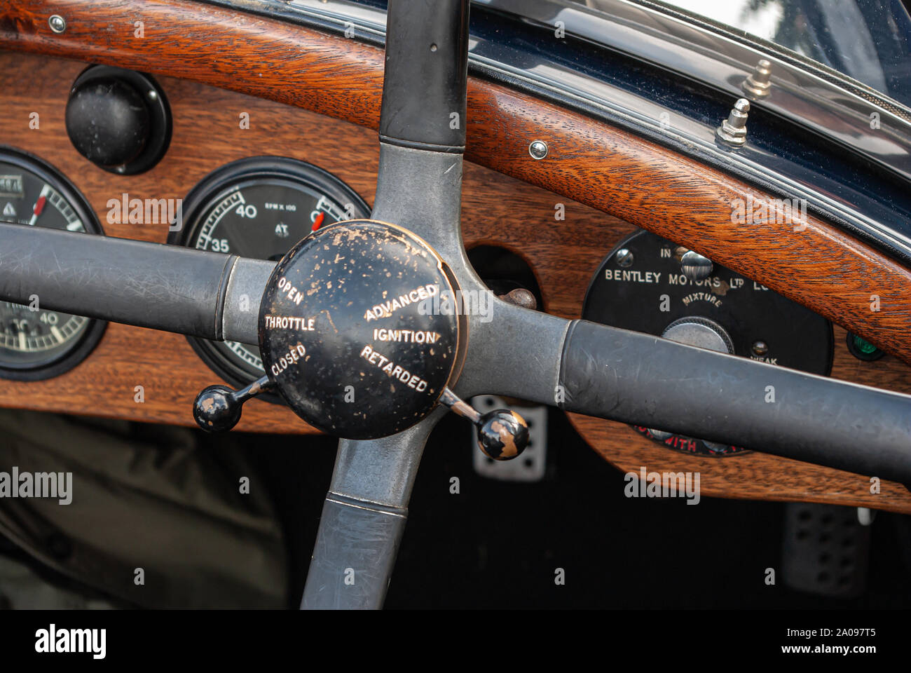 Dashboard and steering wheel of vintage Bentley car showing throttle