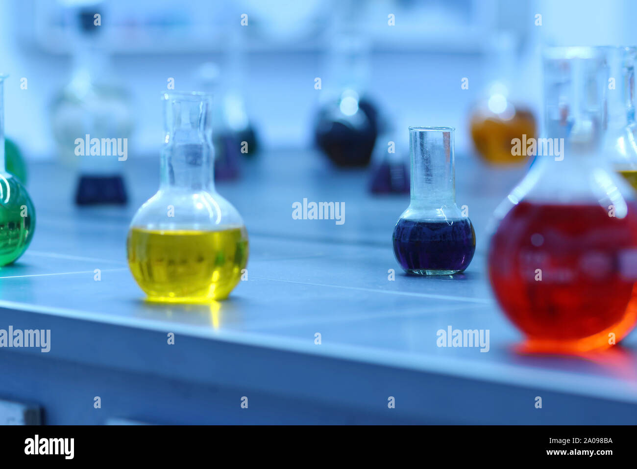 Laboratory glassware with colorful liquids on lab table. Science and ...