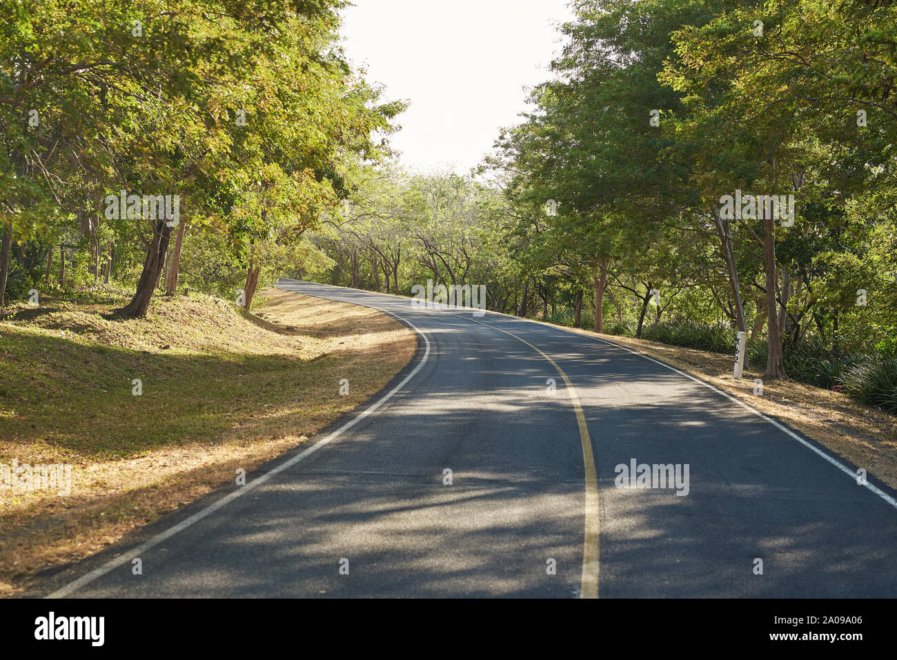 Left turn on country road on sunny bright day Stock Photo