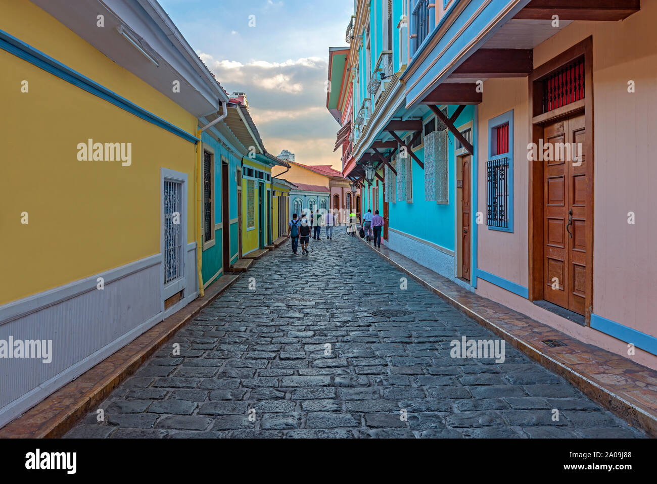 People walking by the colonial style architecture cobblestone street of Guayaquil at sunset, Santa Ana Hill, Las Penas District, Guayaquil, Ecuador. Stock Photo