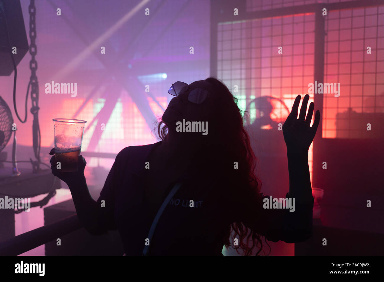 Dancing young woman silhouette at techno club Stock Photo
