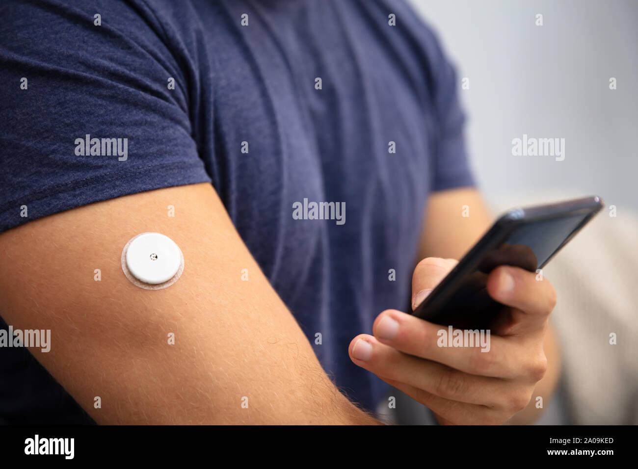 Man Testing Glucose Level With Continuous Glucose Monitor On Mobile Phone Stock Photo