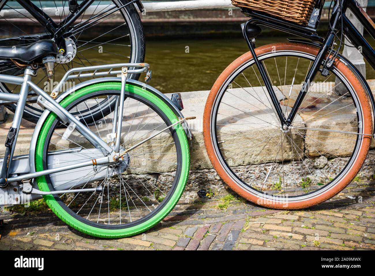 Bicycles with blak, green and orange tires on brick straat Stock Photo