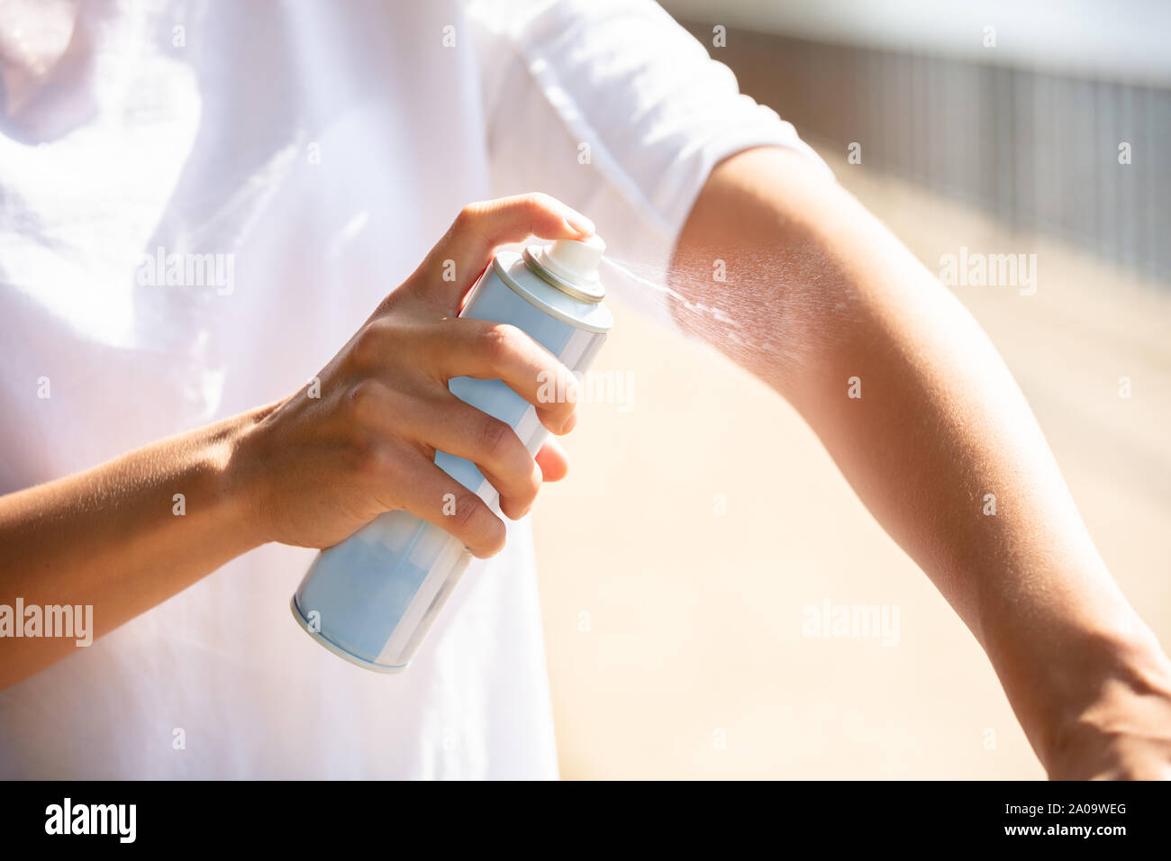 Close-up Of A Woman's Hand Spraying Anti Insect Deet Spray On Skin Outdoors Stock Photo