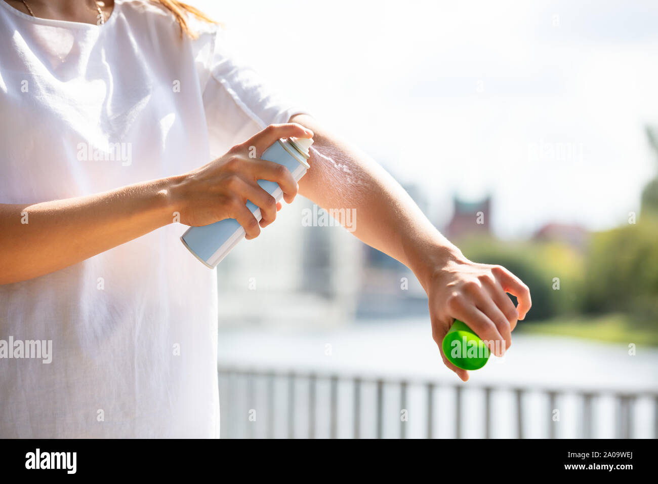 Close-up Of A Woman's Hand Spraying Anti Insect Deet Spray On Skin Outdoors Stock Photo