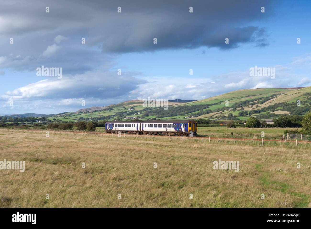Arriva Northern rail class 156 sprinter train passing Dunnerholme on the scenic Cumbrian coast railway line in Cumbria Stock Photo