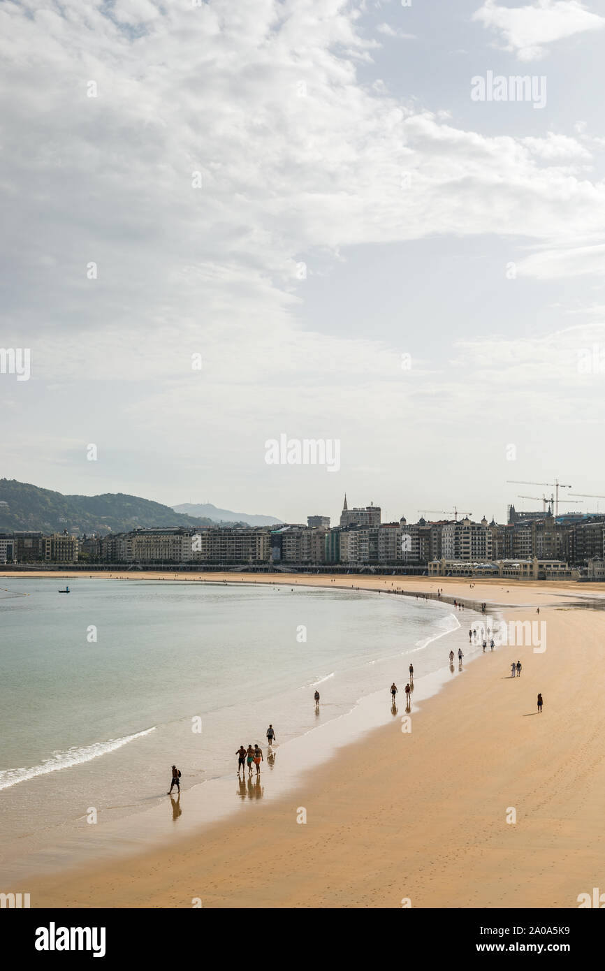 people walking along the beach on a Monday morning in San Sebastian, Spain. Stock Photo