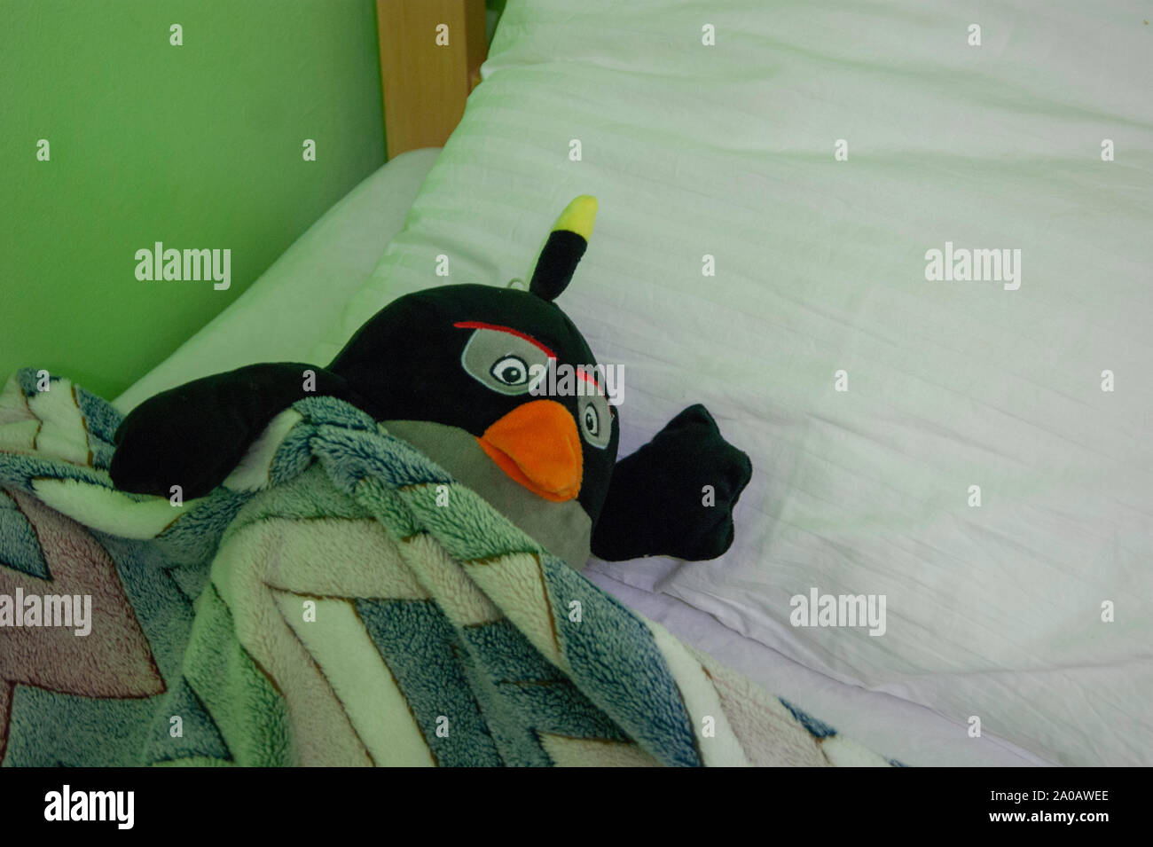Good night - a soft toy penguin on a pillow invites to keep him company tonight Stock Photo