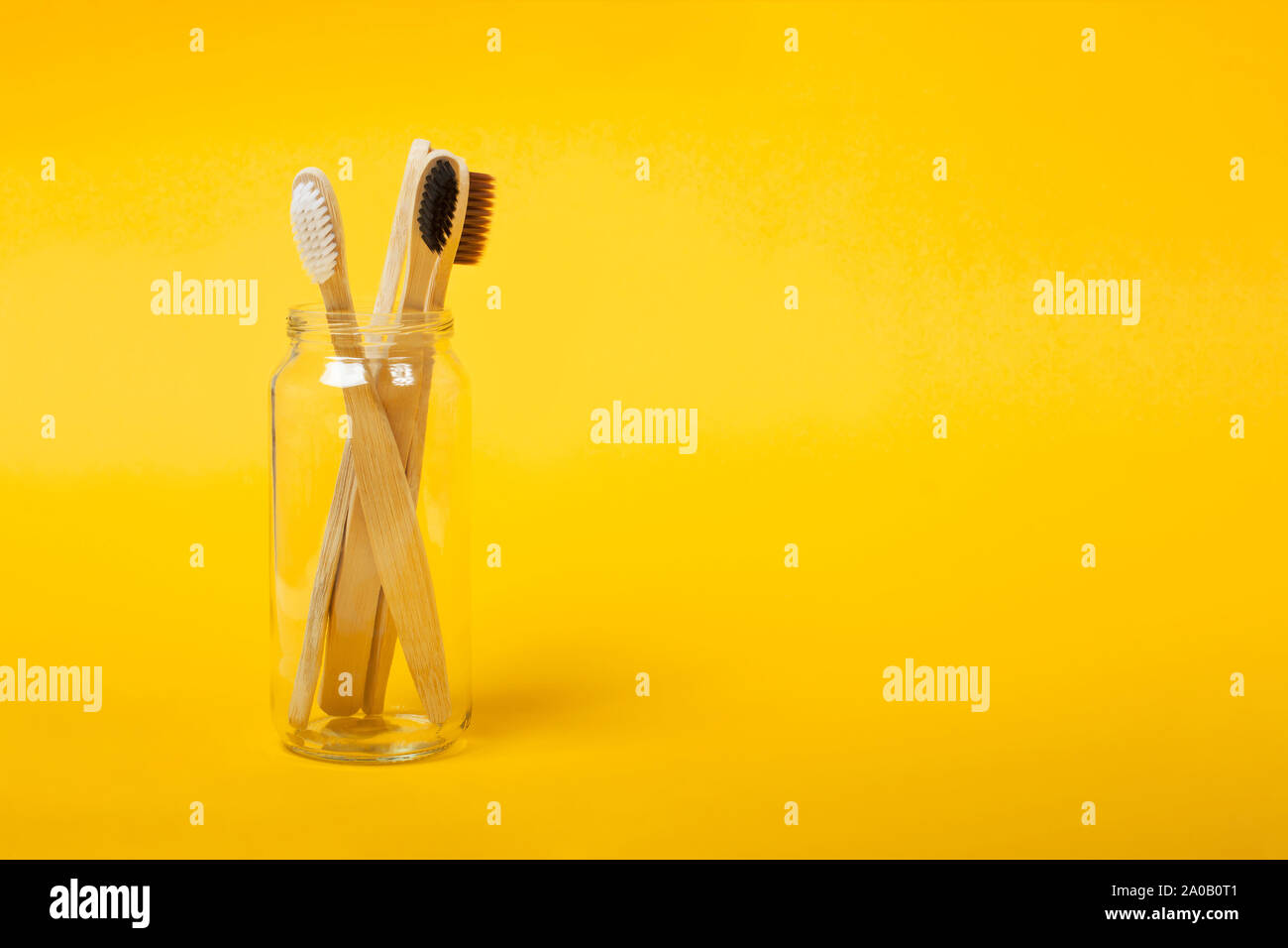 Set of four eco friendly bamboo toothbrushes on the yellow background ...