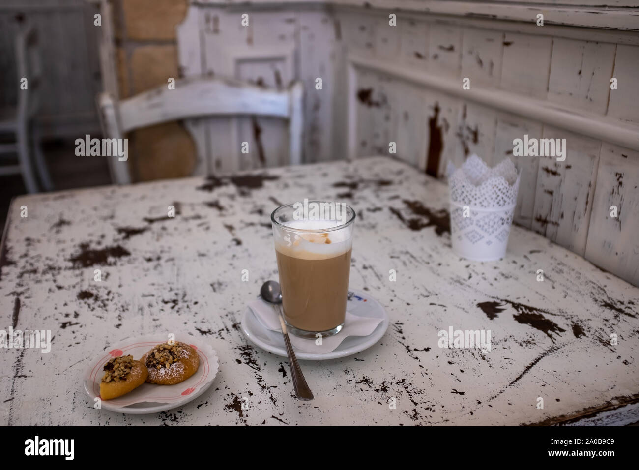 Simple but delicious breakfast in an Italian bar: latte macchiato (spotted milk) and small chocolate pastries. Stock Photo