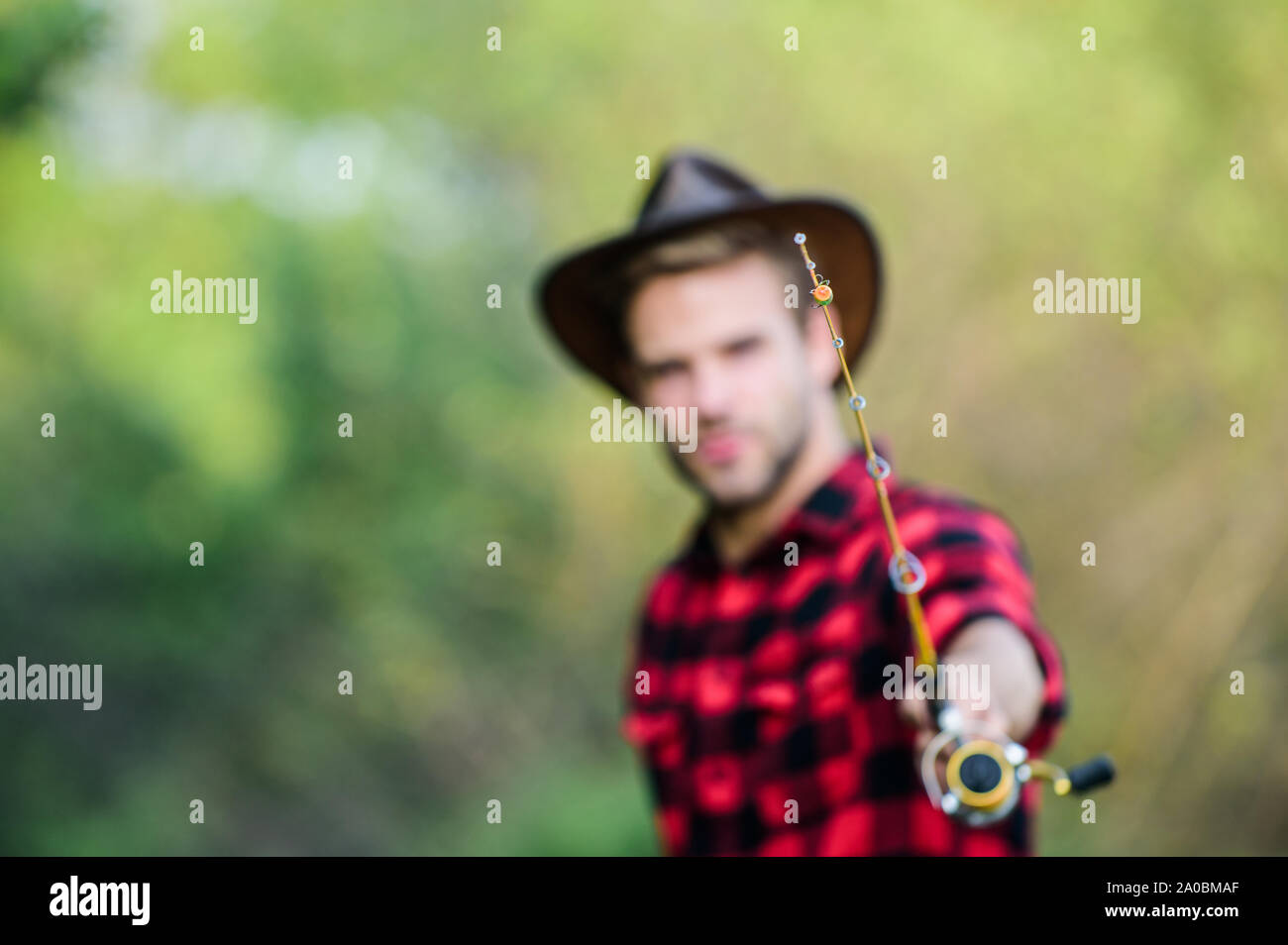 Hook and bait. Fishing hobby. Guy in cowboy hat fishing equipment nature  background defocused. Hipster fisherman hold rod spinning selective focus.  Hope for nice fishing. Fishing day. Proper fishhook Stock Photo 