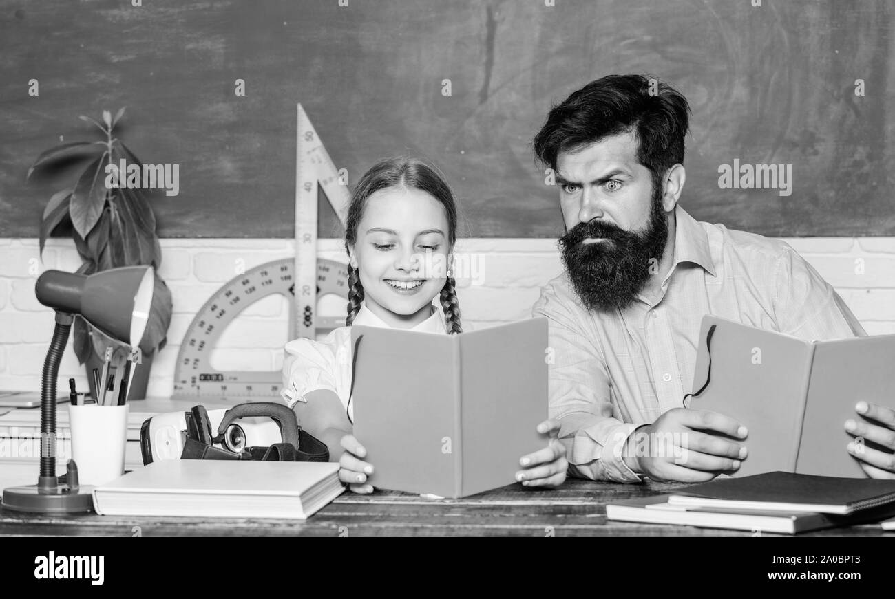 Concentrated on studying. small girl child with bearded teacher man in classroom. daughter study with father. Teachers day. back to school. Private teaching. knowledge. Home schooling. private lesson. Stock Photo