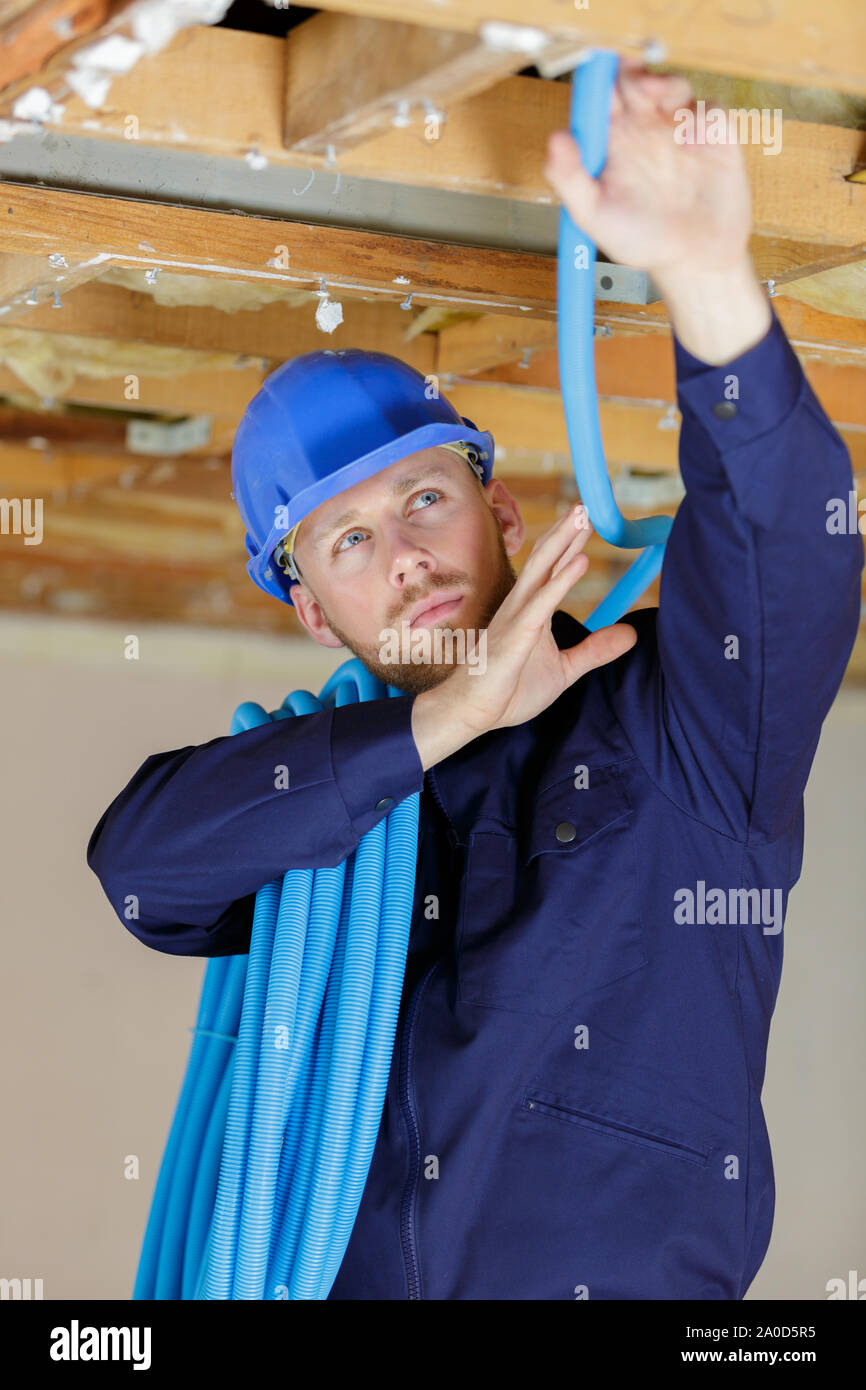 a plumber checking ceiling pipes Stock Photo
