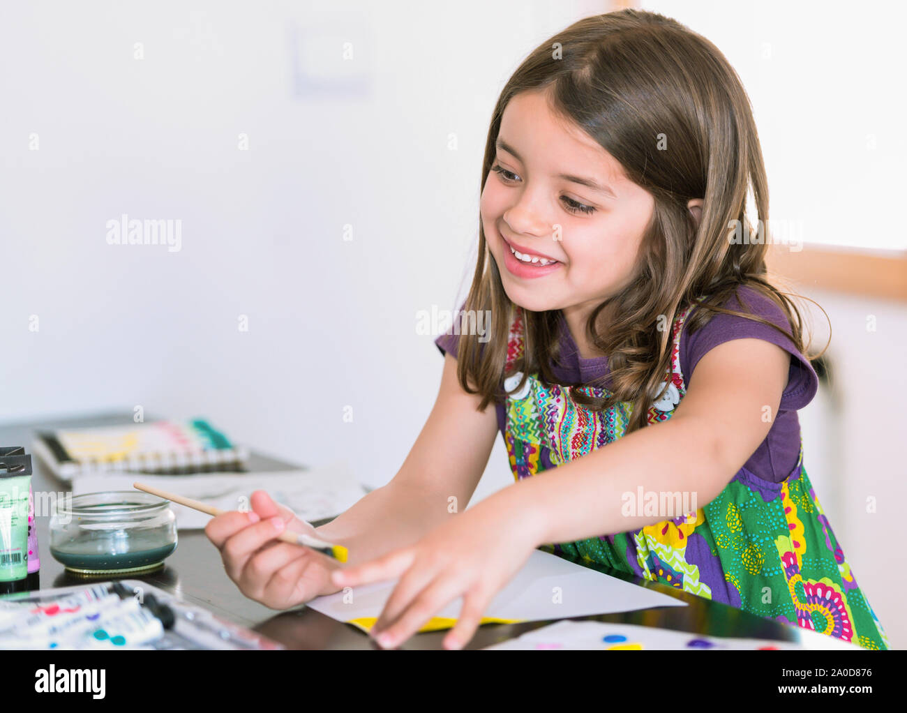 Portrait of a cute smiling girl painting a picture Stock Photo - Alamy