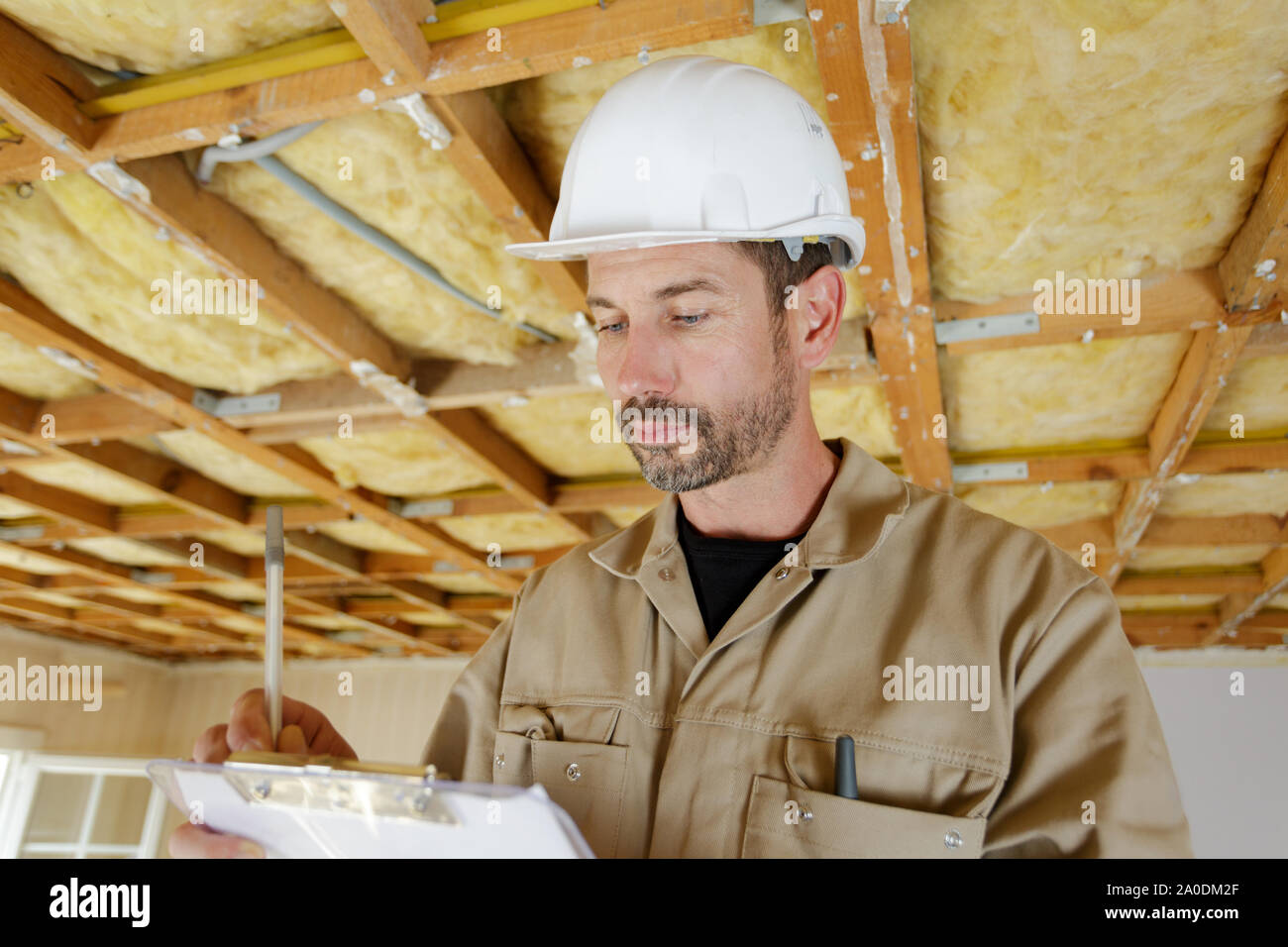 male builder making notes on a clipboard Stock Photo