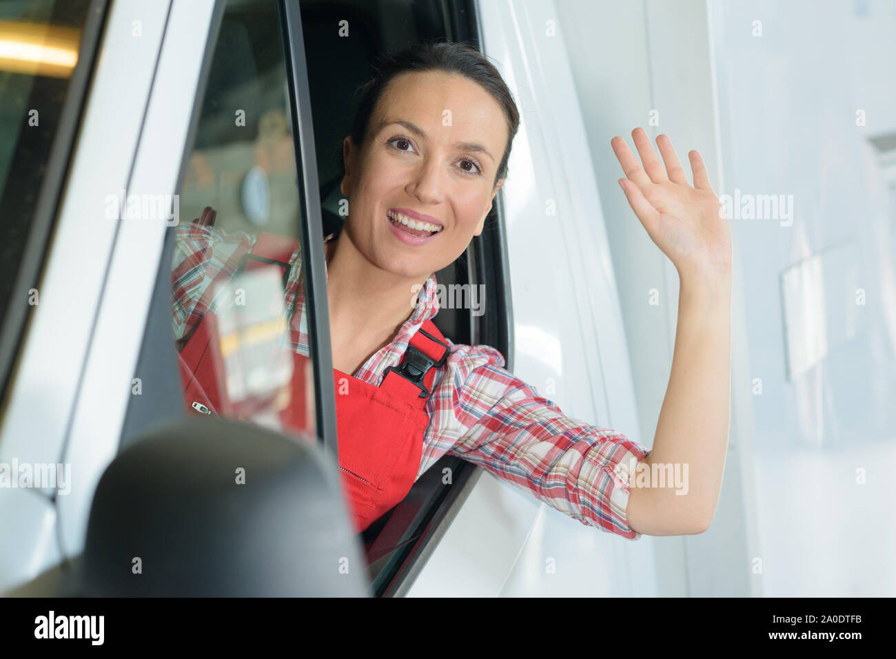 female van driver waving at camera Stock Photo