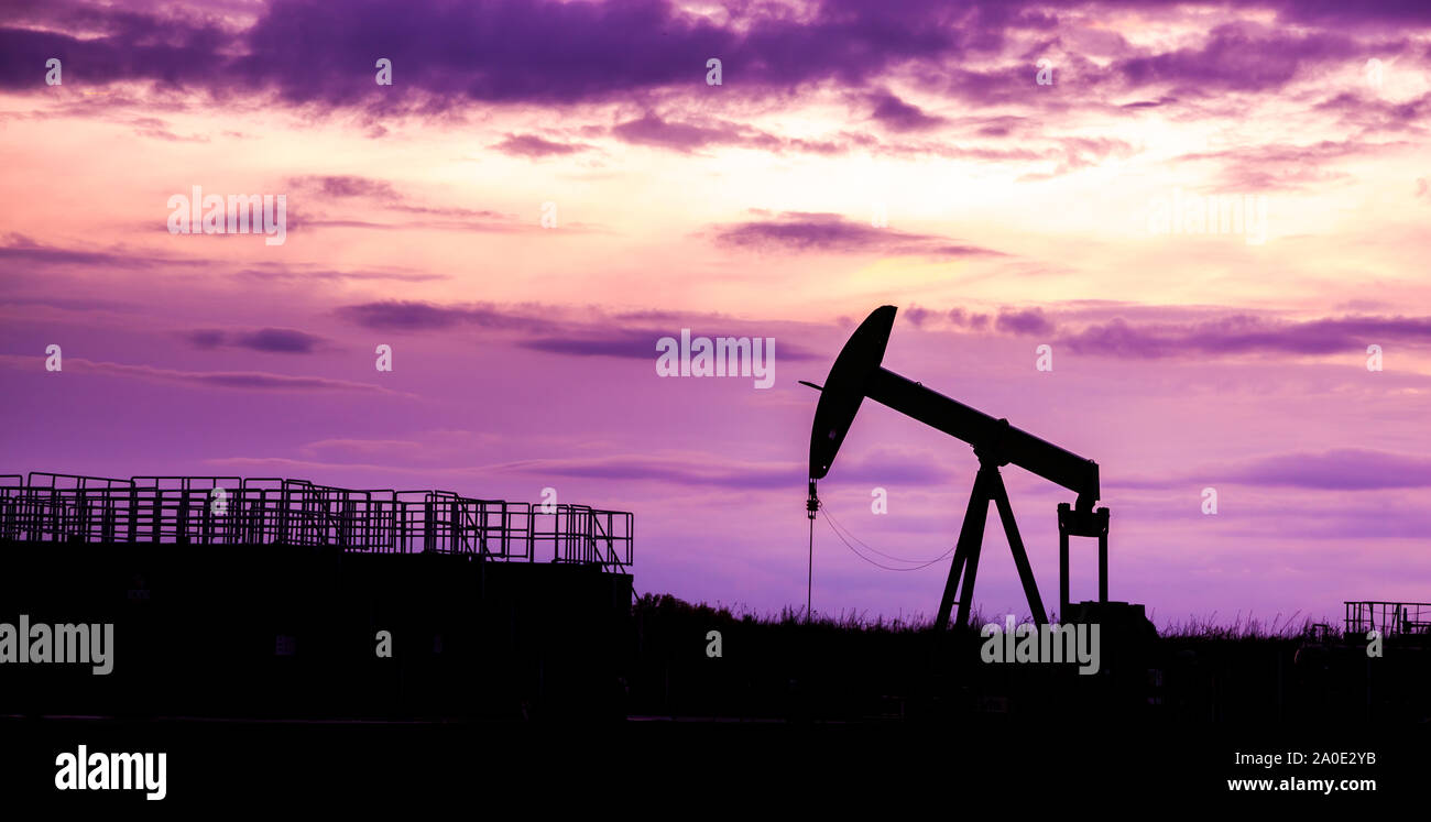 Silhouette of Oil pumps at oil field with nice sunset sky background