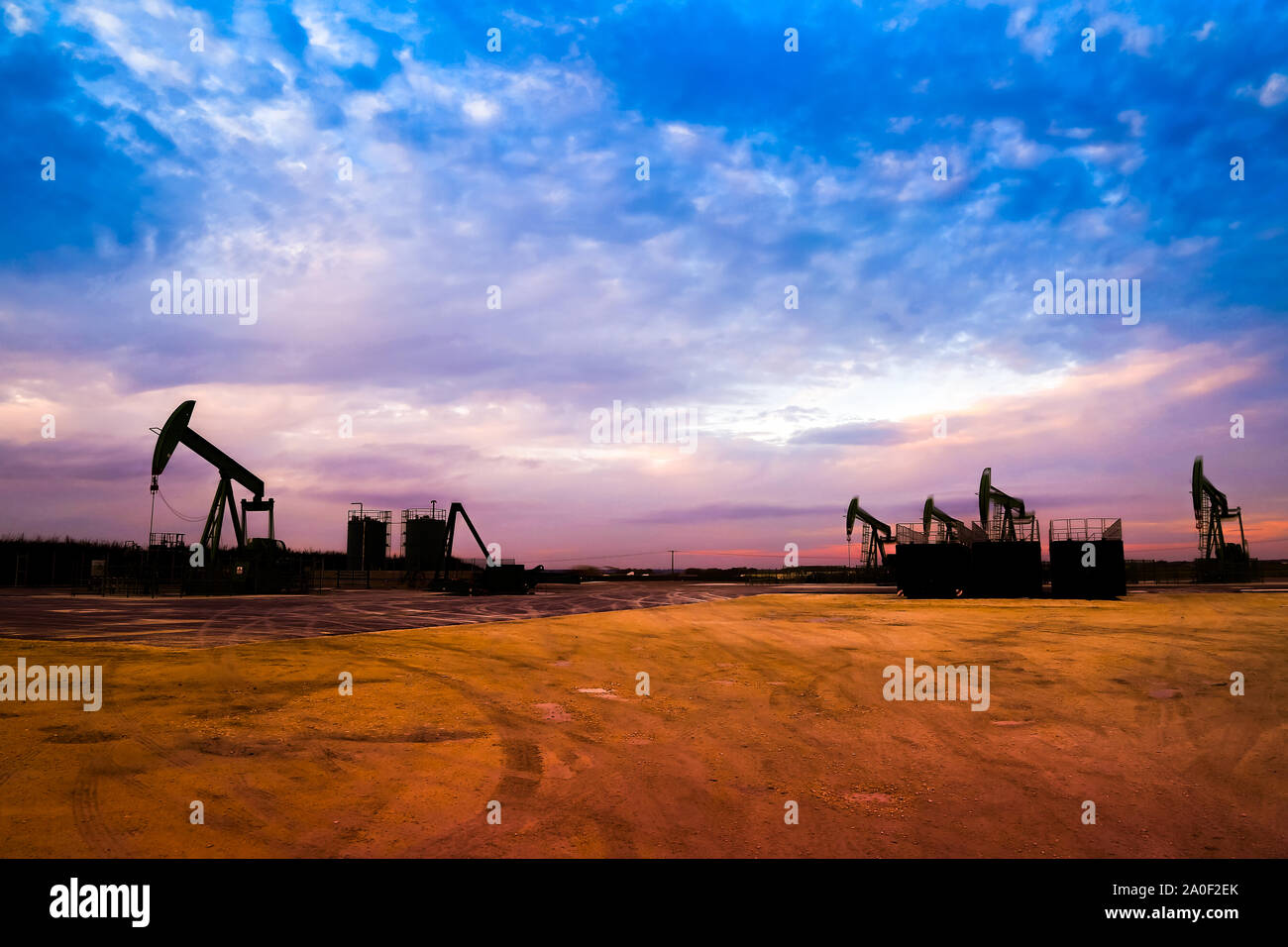 Silhouette of Oil pumps at oil field with nice sunset sky background