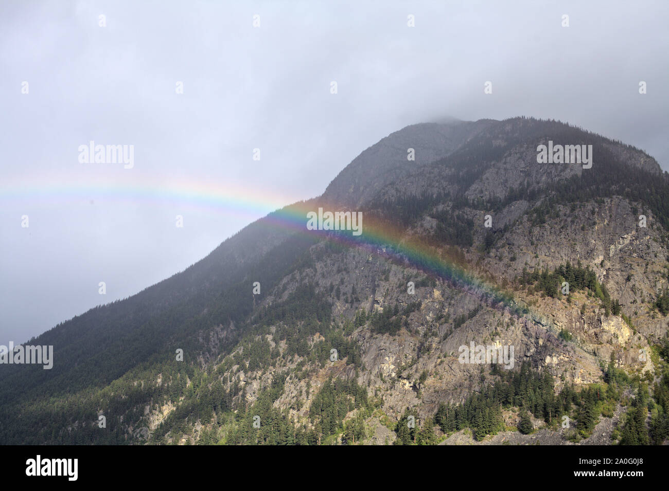 A partial rainbow in front of a mountain peak, seen hiking on Goat