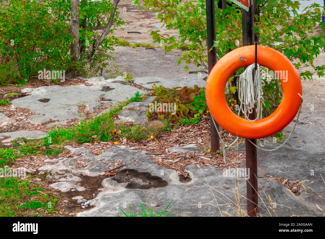 An orange flotation device hangs with rope outside. Stock Photo