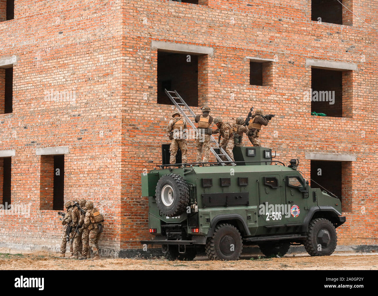 Personnel assigned to the Department of State Guard of Ukraine infiltrate a building during an antiterrorism raid rehearsal as part of Rapid Trident 2019 at Combat Training Center-Yavoriv, Sept. 18, 2019. Stock Photo