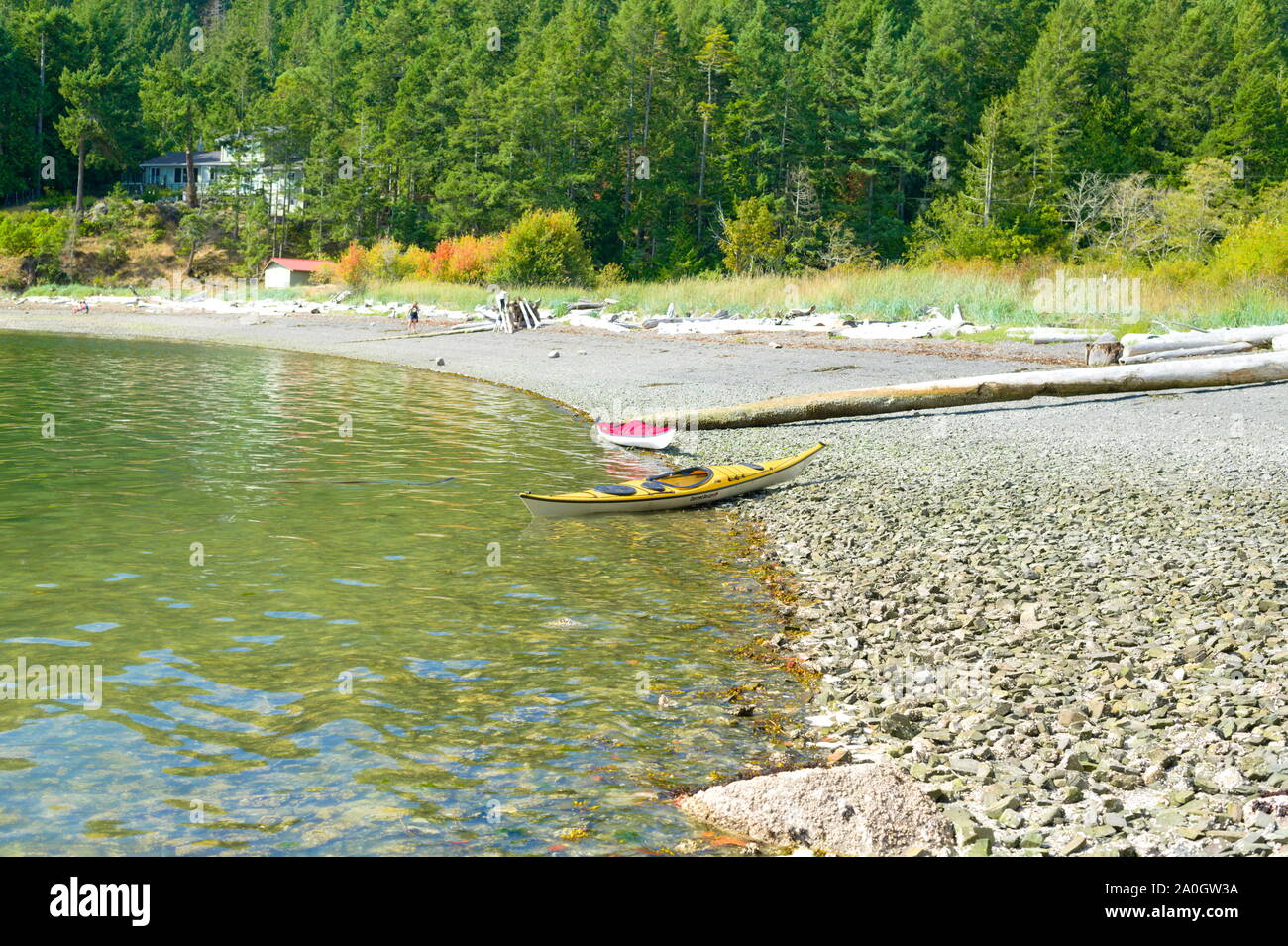 A yellow kayak on the beach on Medicine Beach in North Pender Island, British Columbia, Canada Stock Photo
