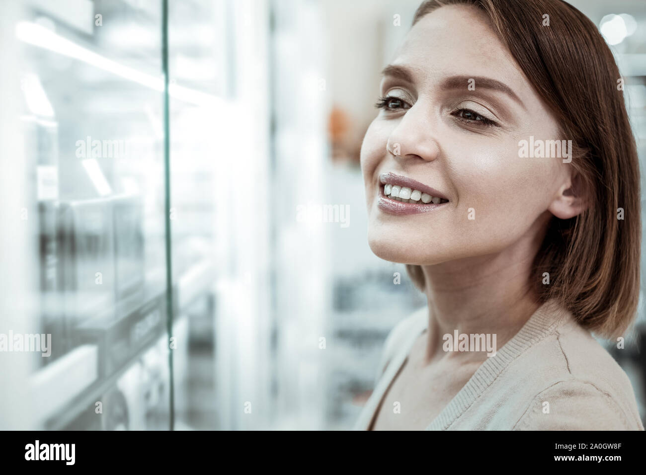 A comely female looking at the drugstore window with pills. Stock Photo