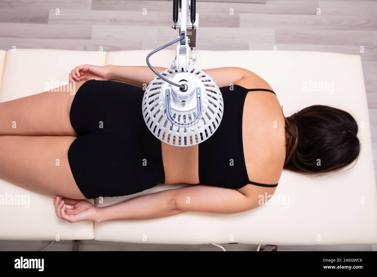 Medicinal Infrared Radiating Treatment On Woman's Back Lying On Bed In Medical Clinic Stock Photo