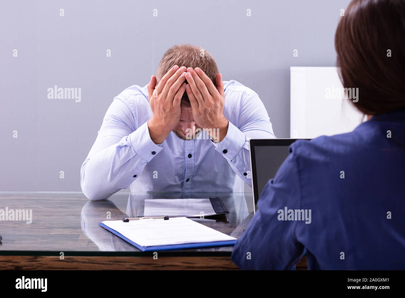 Stressed Young Business Man Holding His Head At Interview In Office ...
