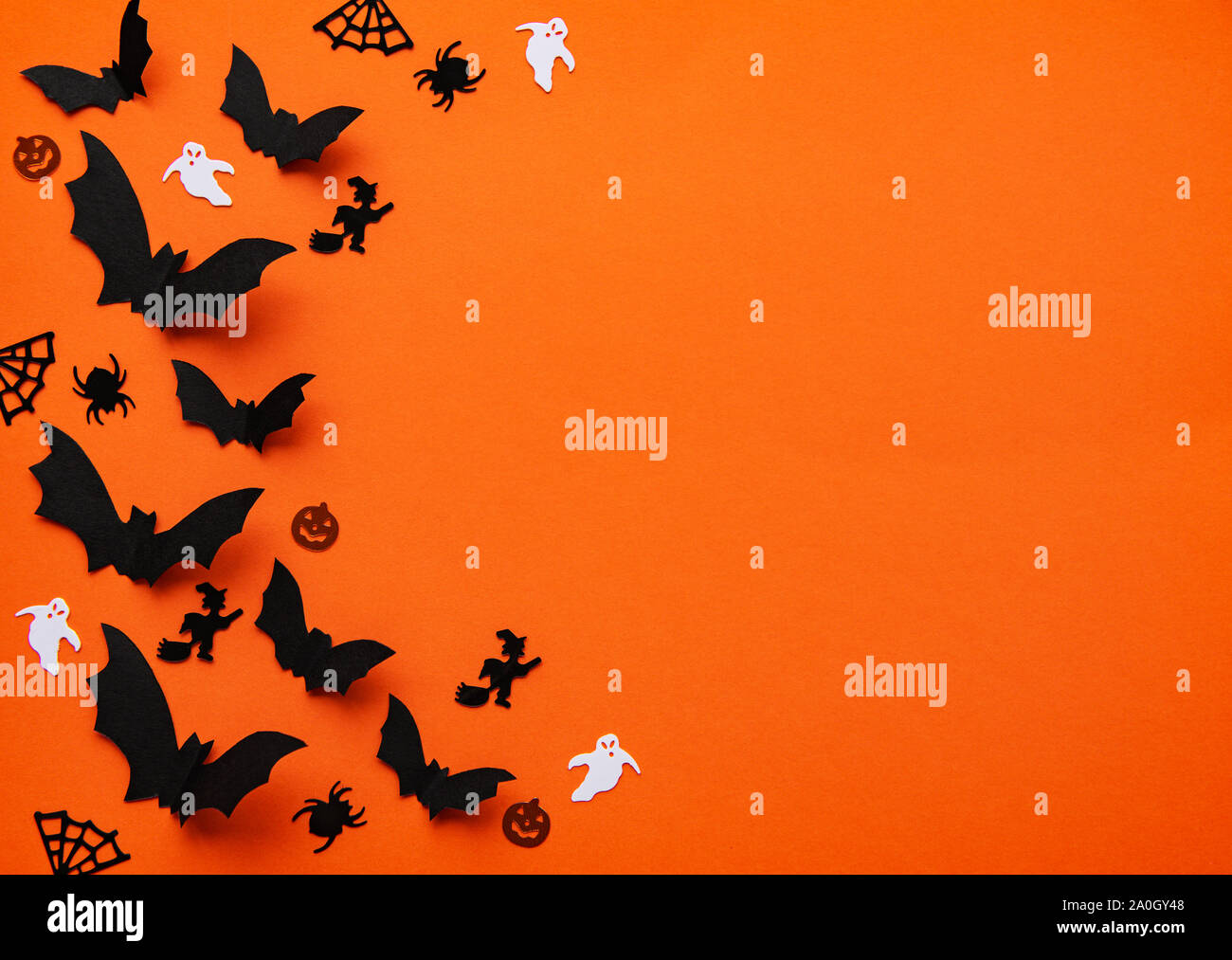 halloween concept - black paper bats and decorations flying over orange ...
