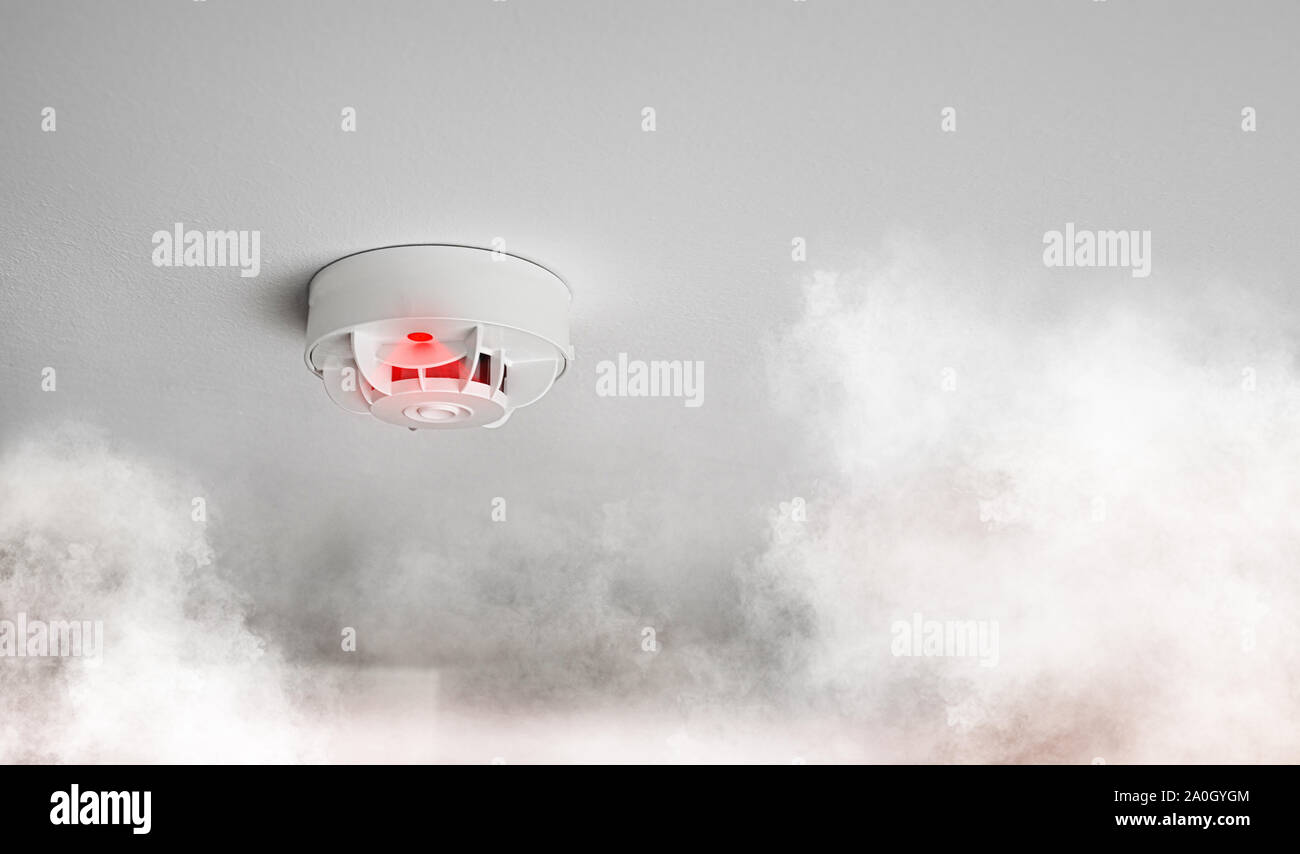 close-up of smoke alarm or smoke detector in home going off with thick smoke Stock Photo