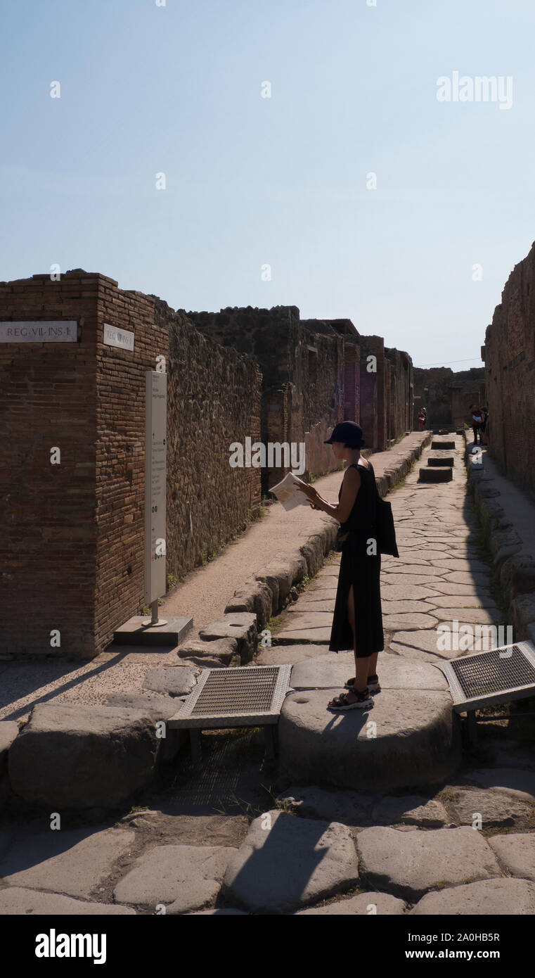 Japanese female tourist waking trough the streets of Pompeii, Campania Italy Stock Photo