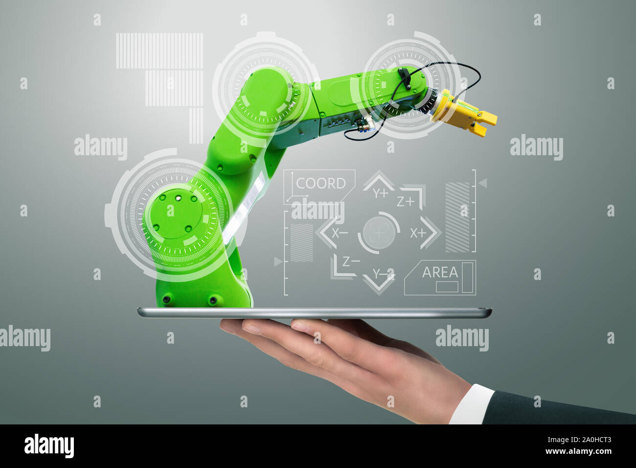 Man holding a digital tablet with handling robot with robotic arm. Stock Photo