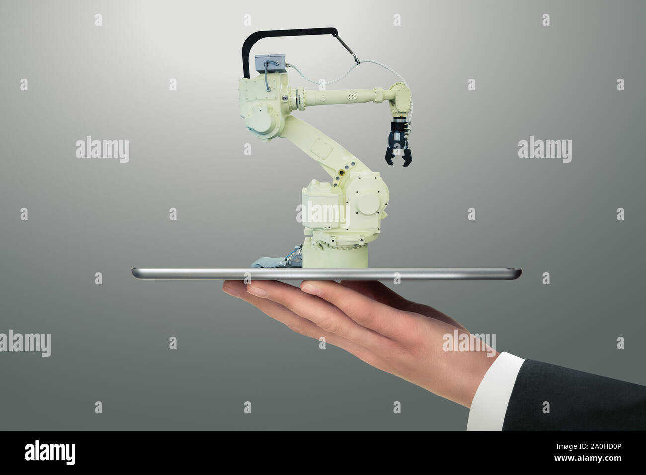 Man holding a digital tablet with handling robot with robotic arm. Stock Photo