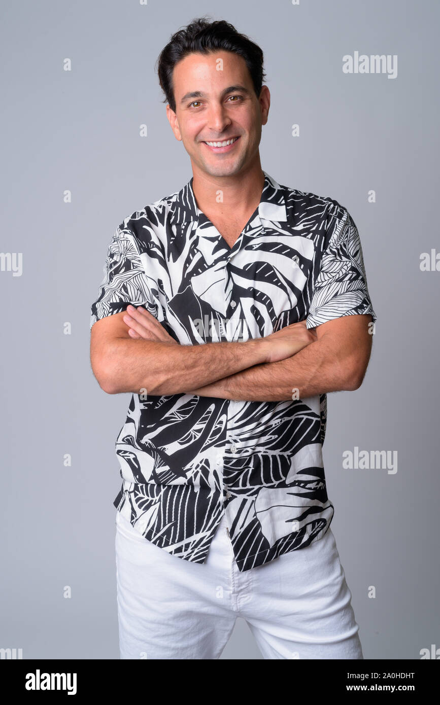 Portrait of happy handsome Hispanic tourist man smiling with arms ...