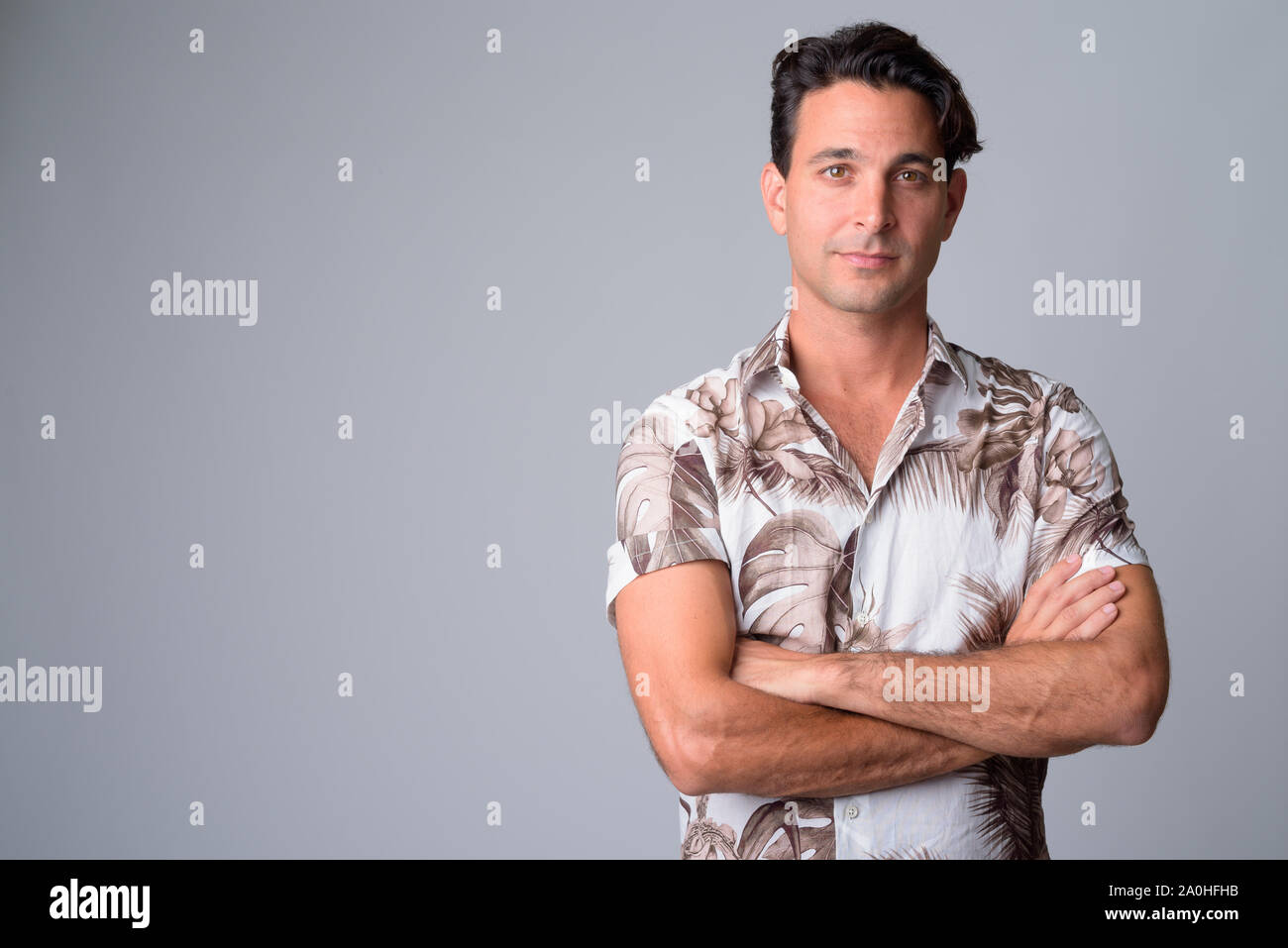 Portrait of handsome Hispanic tourist man with arms crossed Stock Photo ...
