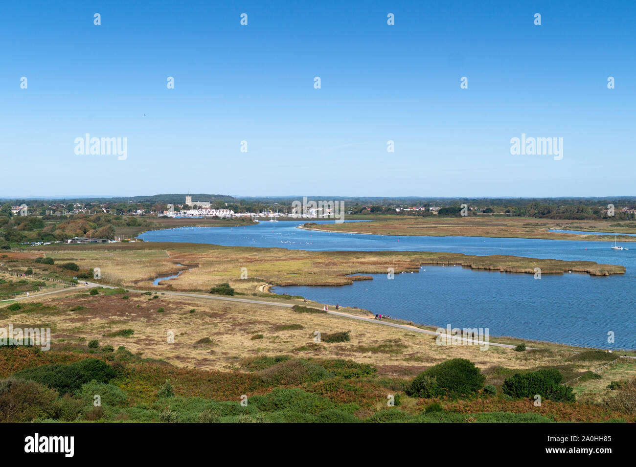 Christchurch Harbour viewed from Hengistbury Head, Christchurch and the Priory can clearly be seen alongside Stanpit Marsh. Stock Photo