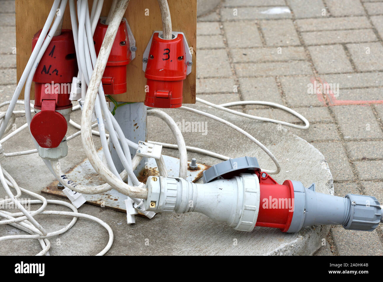 Electrical extension cord with plugs, extension lead. Electric extension cord on ground Stock Photo