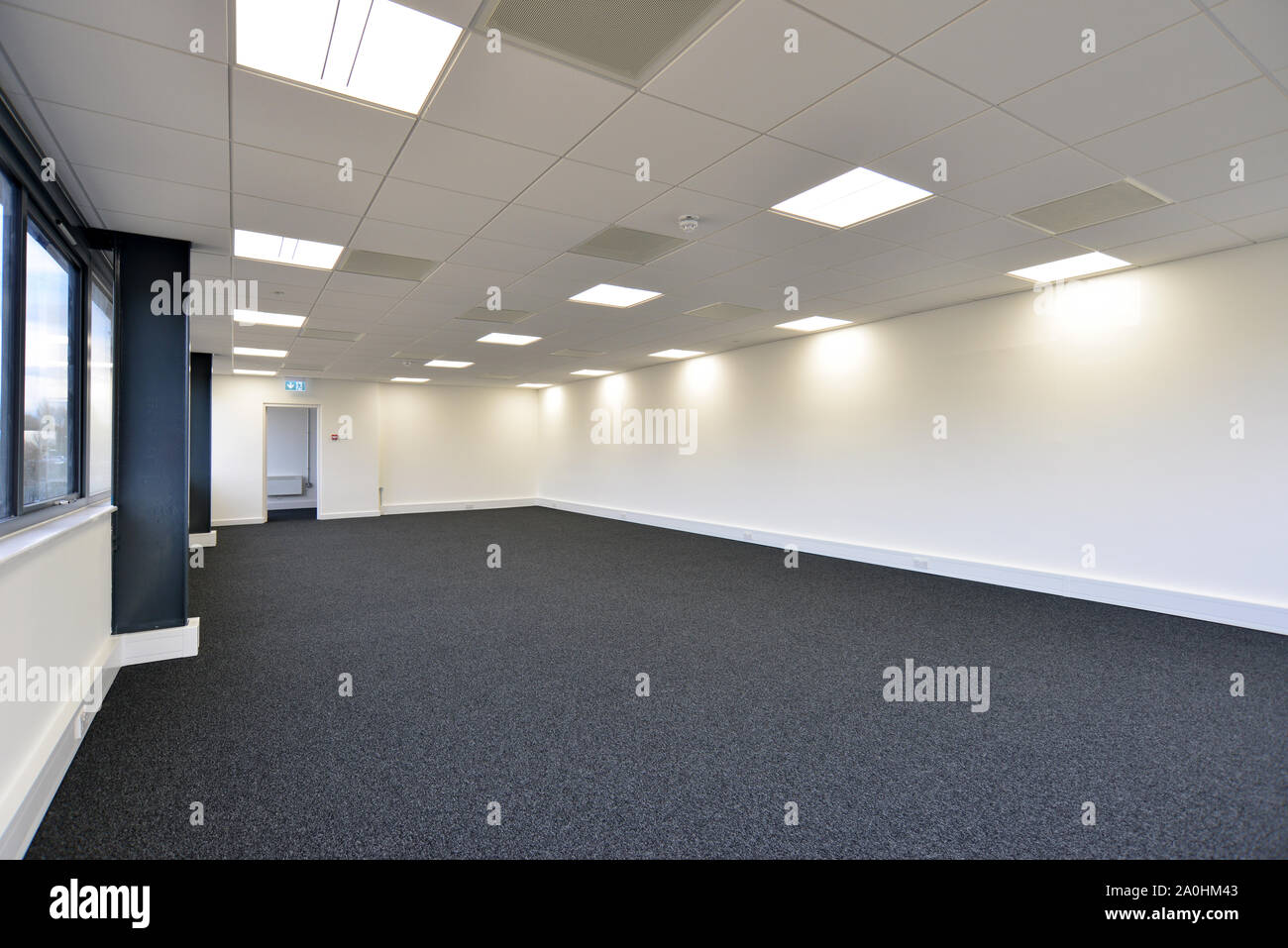 an empty office space with carpet and open door Stock Photo