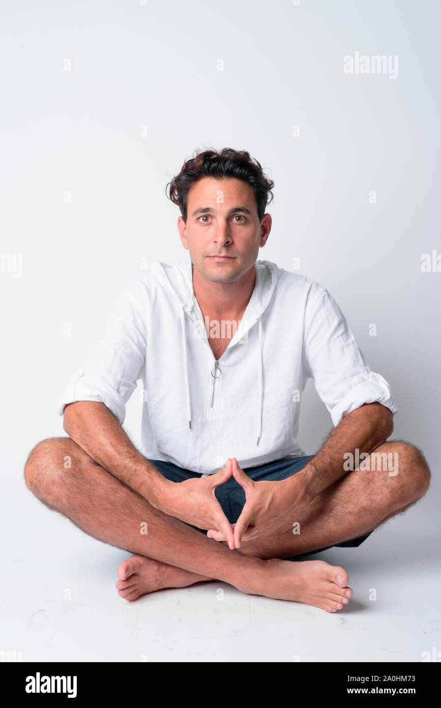 Full body shot of handsome Hispanic man sitting with legs crossed Stock ...