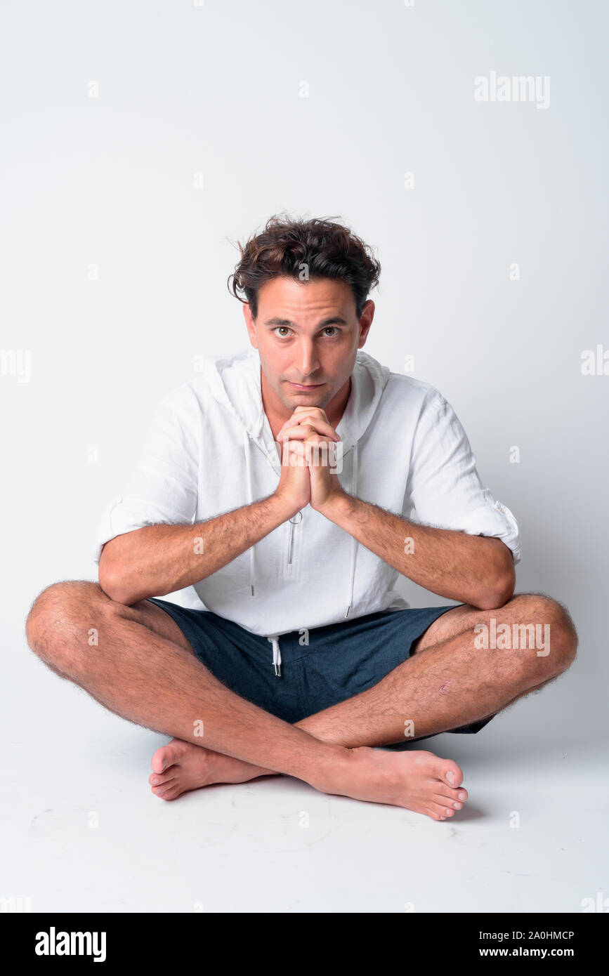 Full body shot of handsome Hispanic man sitting with legs crossed Stock ...