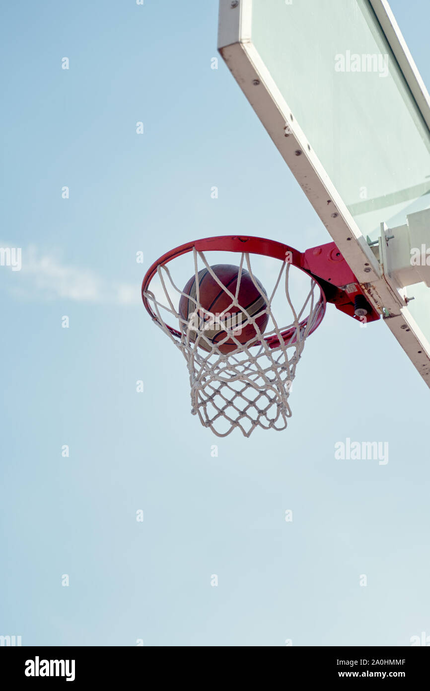 Photo of basketball hoop against blue sky on summer day Stock Photo