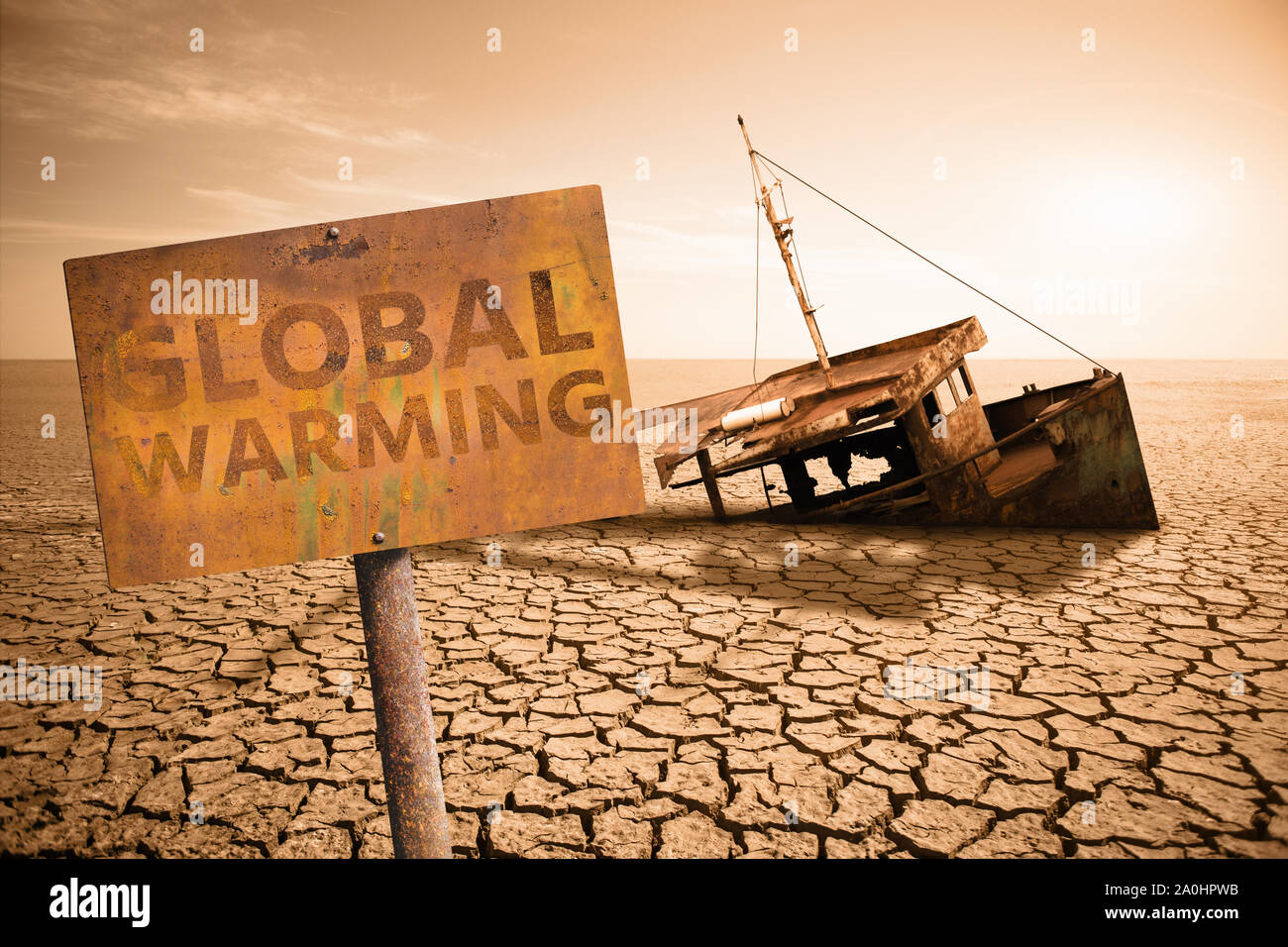 Rusty sign with text 'Global warming' on a background of old ship in a dried ocean.  Climate change concept. Stock Photo
