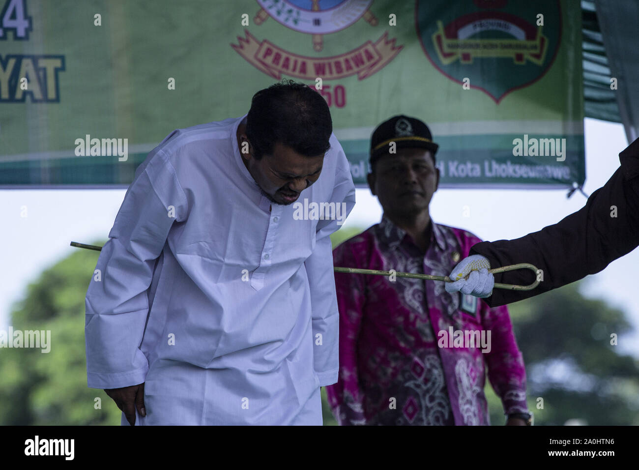 Lhokseumawe, Aceh, Indonesia. 20th Sep, 2019. A man who was caught having an affair with someone else's wife grimaced in pain when he was whipped by sharia officials at a stadium in Lhokseumawe, Aceh. The couple who were caught having an affair were whipped 9 times each for violating Islamic Sharia law in Aceh which is the most conservative province of Islamic law in Indonesia. Credit: Zikri Maulana/ZUMA Wire/Alamy Live News Stock Photo