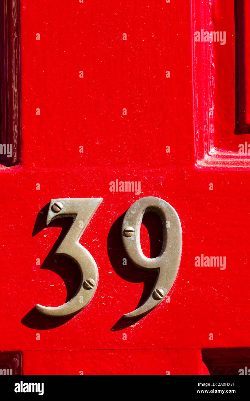 House number 39 on a bright red wooden front door Stock Photo