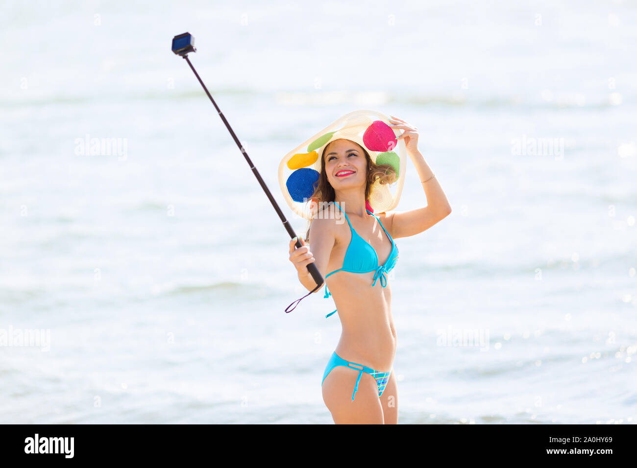 Caucasian woman in bikini sea beach shoots an action camera video for the  Internet and social networks Stock Photo - Alamy