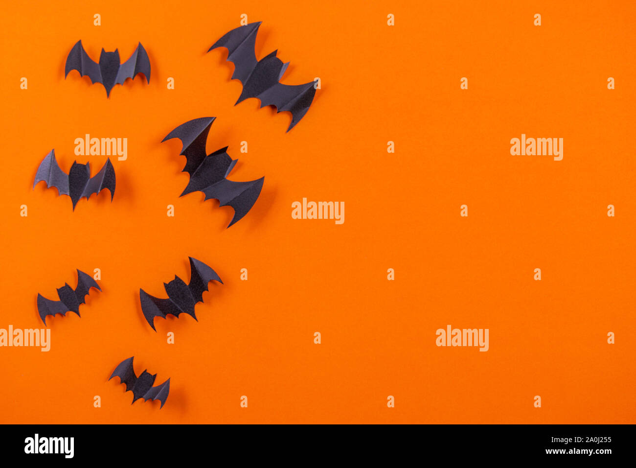 Halloween concept. Flock of black paper bats on orange paper background ...