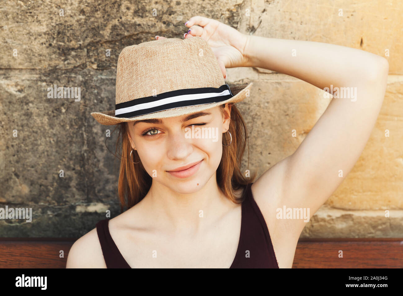 Face portrait of smiling beautiful blond Caucasian girl in a straw hat ...