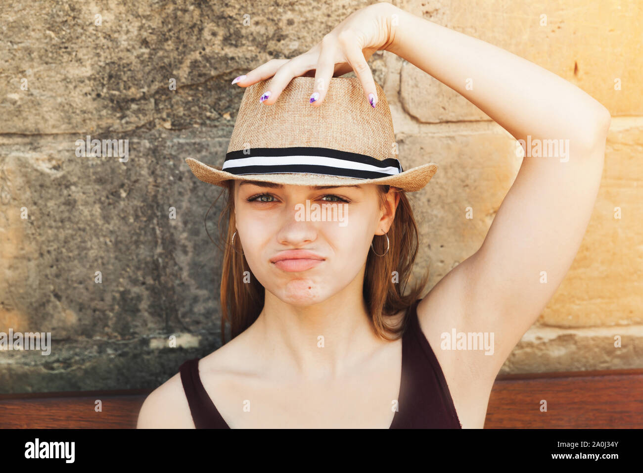 Face portrait of posing beautiful blond Caucasian girl in a straw hat ...